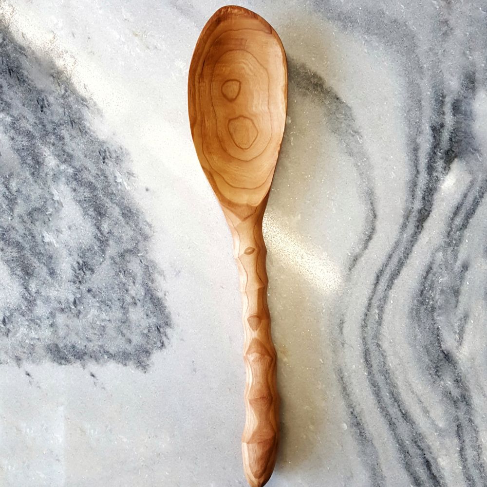 Handcarved Wooden Wild Cherry spoon on a marble surface